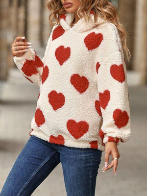 a woman wearing a sweater with hearts on it