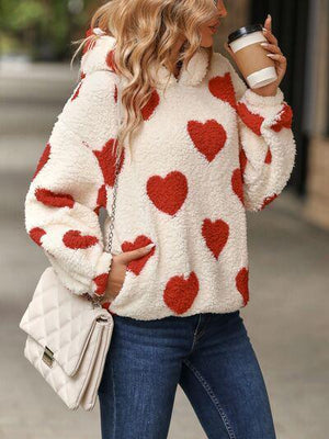 a woman in a red and white sweater holding a cup of coffee