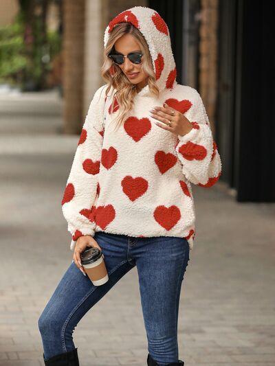 a woman in a red and white heart sweater