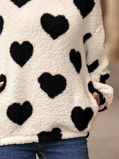 a woman wearing a black and white heart sweater