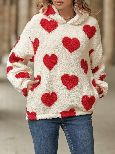 a woman wearing a sweater with hearts on it