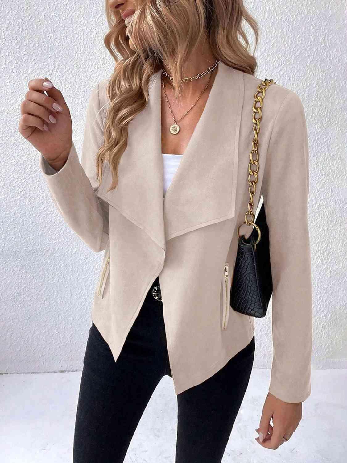 a woman wearing a beige jacket and black pants