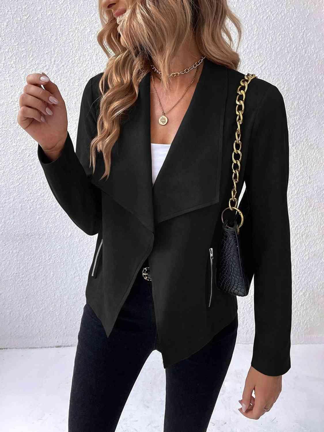 a woman wearing a black blazer and jeans