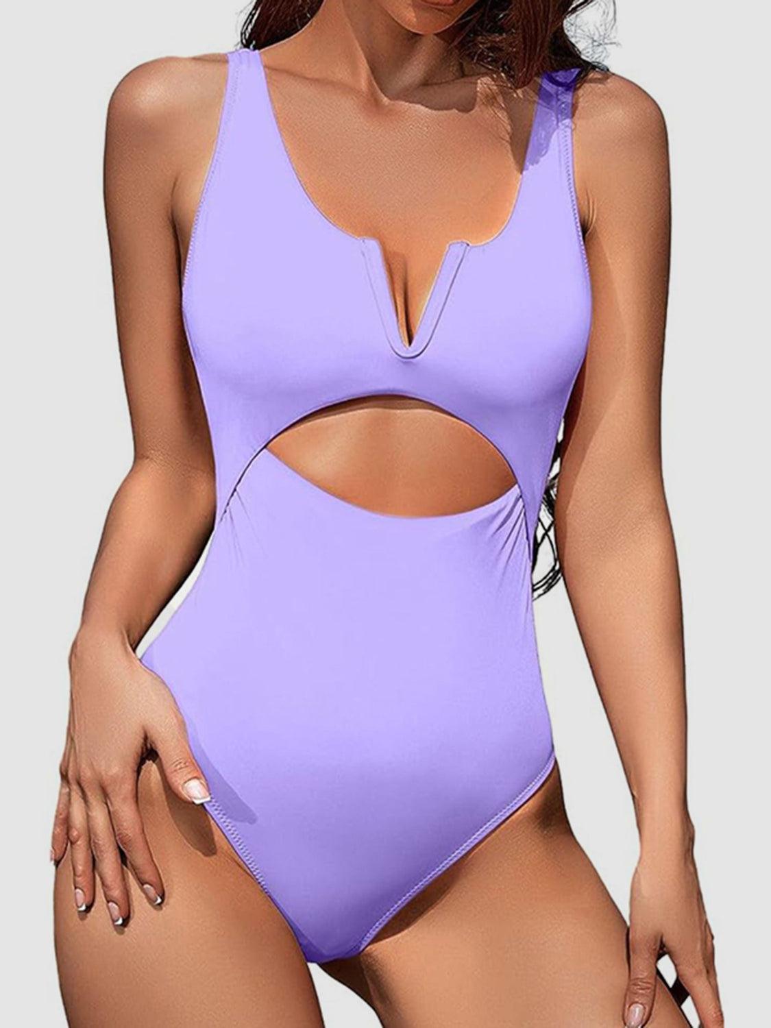 a woman wearing a purple swimsuit with cut outs