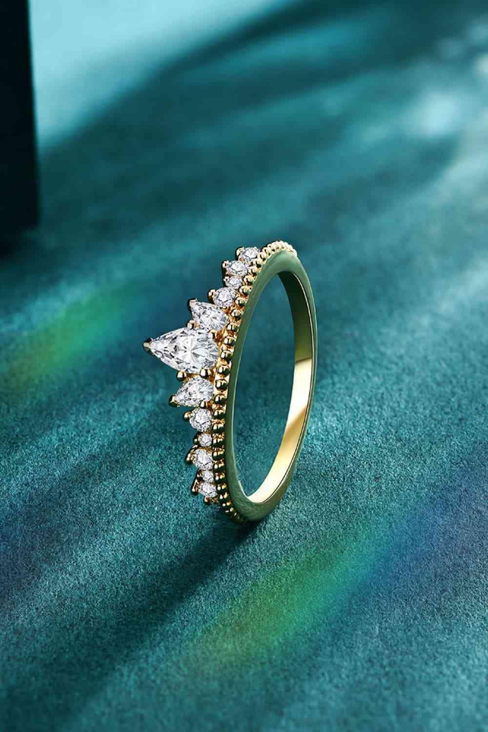 a diamond ring sitting on top of a green surface
