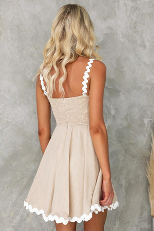 the back of a woman wearing a tan dress