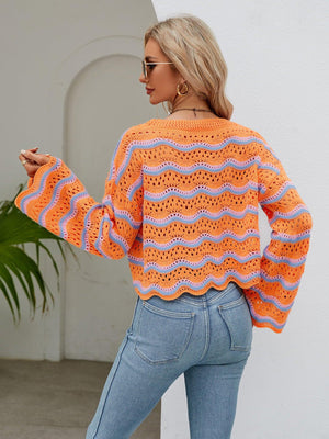 a woman wearing an orange sweater and jeans