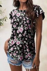 a woman wearing a black top with pink flowers on it