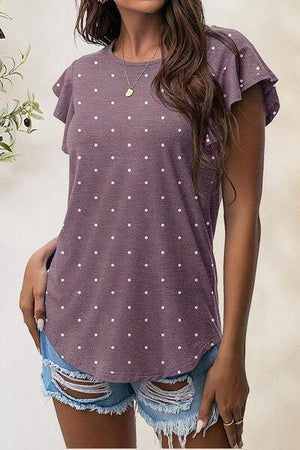 a woman wearing a purple top with white polka dots