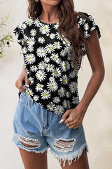 a woman wearing a black and white top with white daisies on it