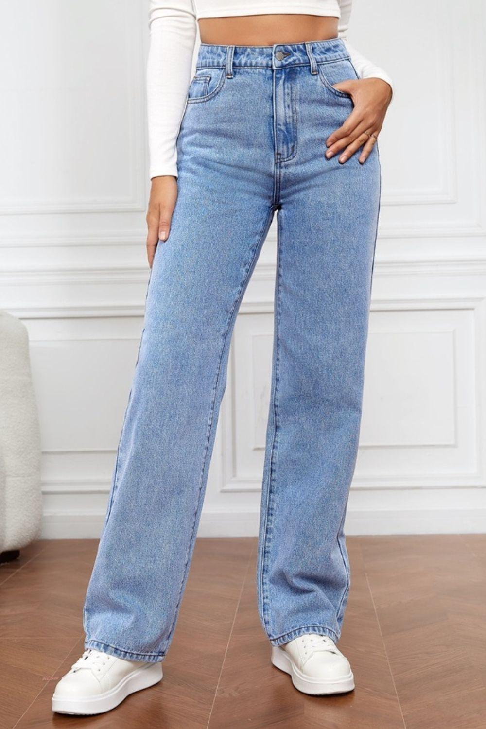 a woman standing on a wooden floor wearing a pair of jeans