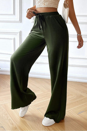 a woman in a crop top and green pants