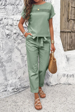 a woman wearing a green top and pants