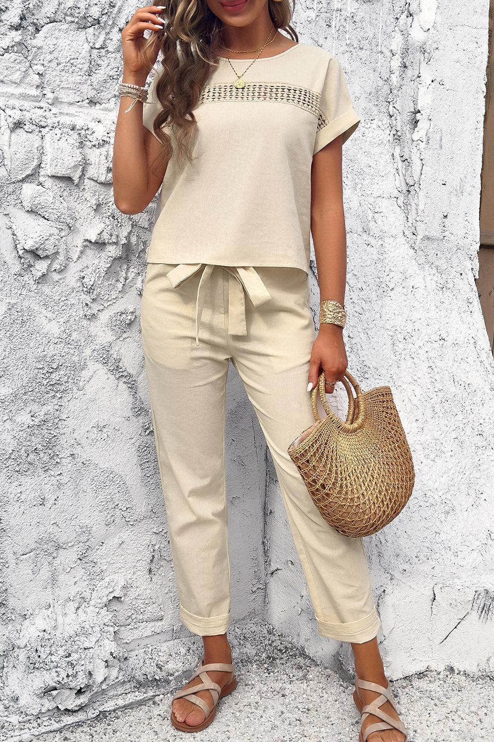 a woman in a white top and beige pants