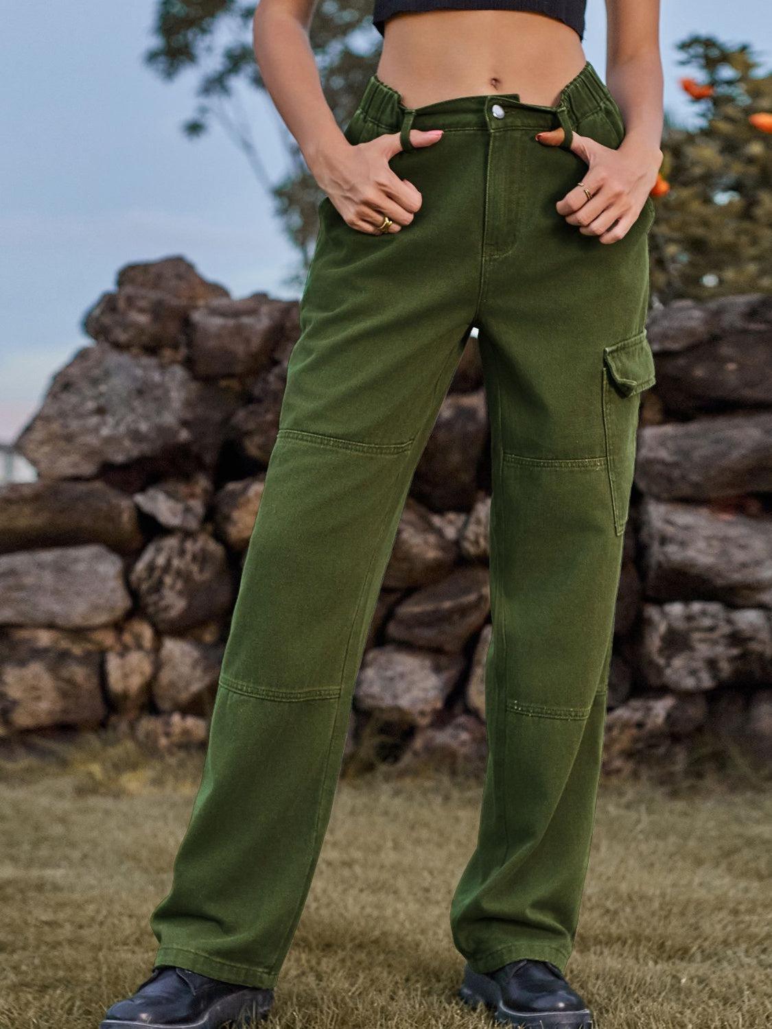 a woman standing in a field with her hands in her pockets