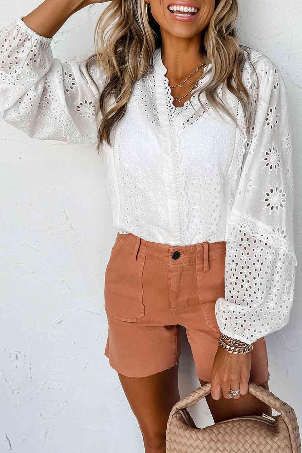 a woman wearing a white blouse and brown shorts