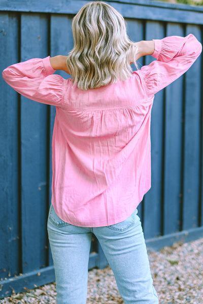 a woman wearing a pink top and jeans