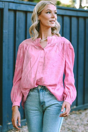 a woman wearing a pink shirt and jeans