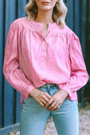 a woman wearing a pink shirt and jeans