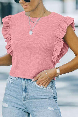 a woman wearing a pink top and ripped jeans