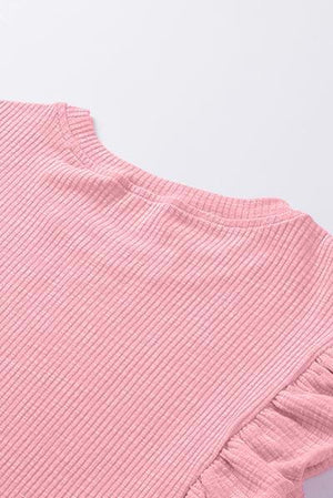 a pink top with ruffles on the bottom