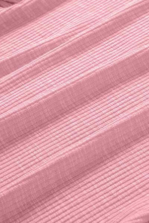 a close up of a bed with a pink bedspread