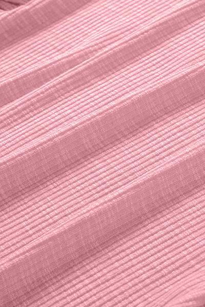 a close up of a bed with a pink bedspread