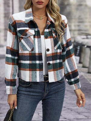 a woman wearing a plaid jacket and jeans