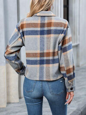 a woman wearing a plaid jacket and jeans