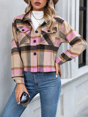 a woman wearing a plaid jacket and hat