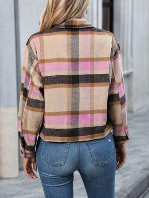 a woman wearing a plaid jacket and jeans