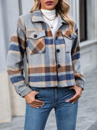 a woman wearing a plaid jacket and jeans