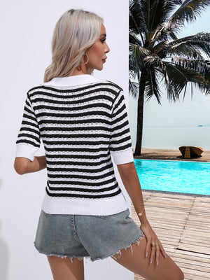 a woman standing next to a pool wearing a black and white striped sweater