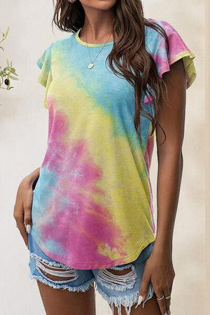 a woman in a tie dye shirt posing for a picture