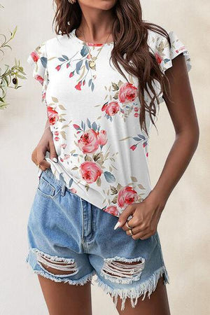 a woman wearing a floral top and denim shorts