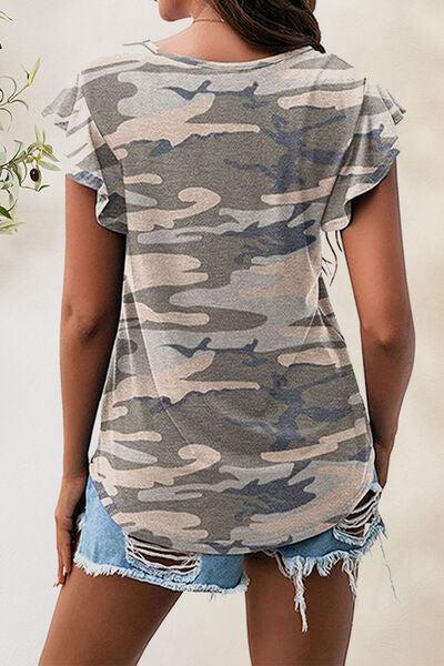 a woman wearing a camo shirt and ripped shorts