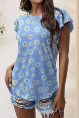 a woman wearing a blue top with daisies on it