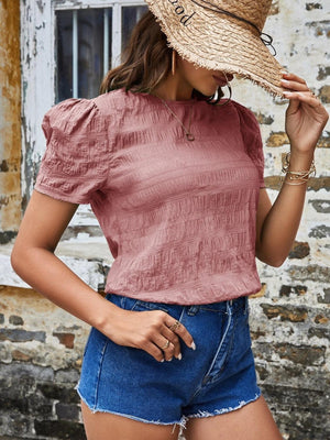 a woman wearing a straw hat and denim shorts