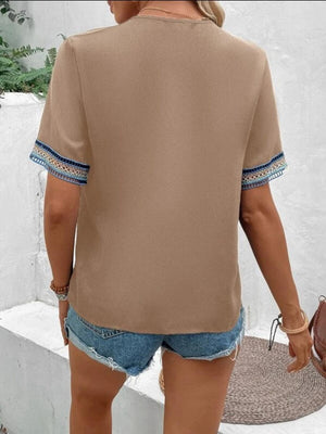 a woman wearing a tan top and denim shorts