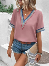 a woman wearing a pink top and denim shorts