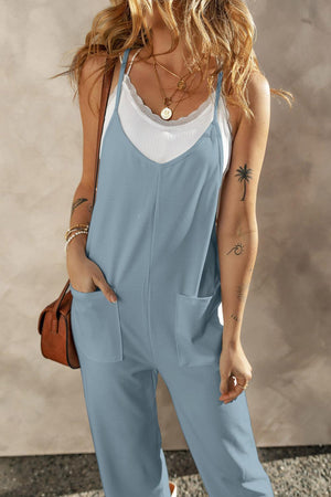 a woman wearing a blue jumpsuit and a white tank top