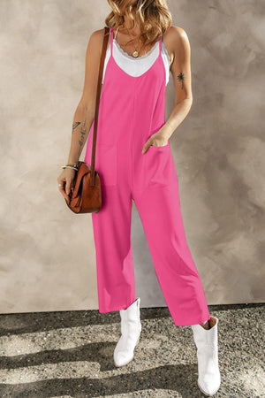 a woman in a pink jumpsuit holding a brown purse