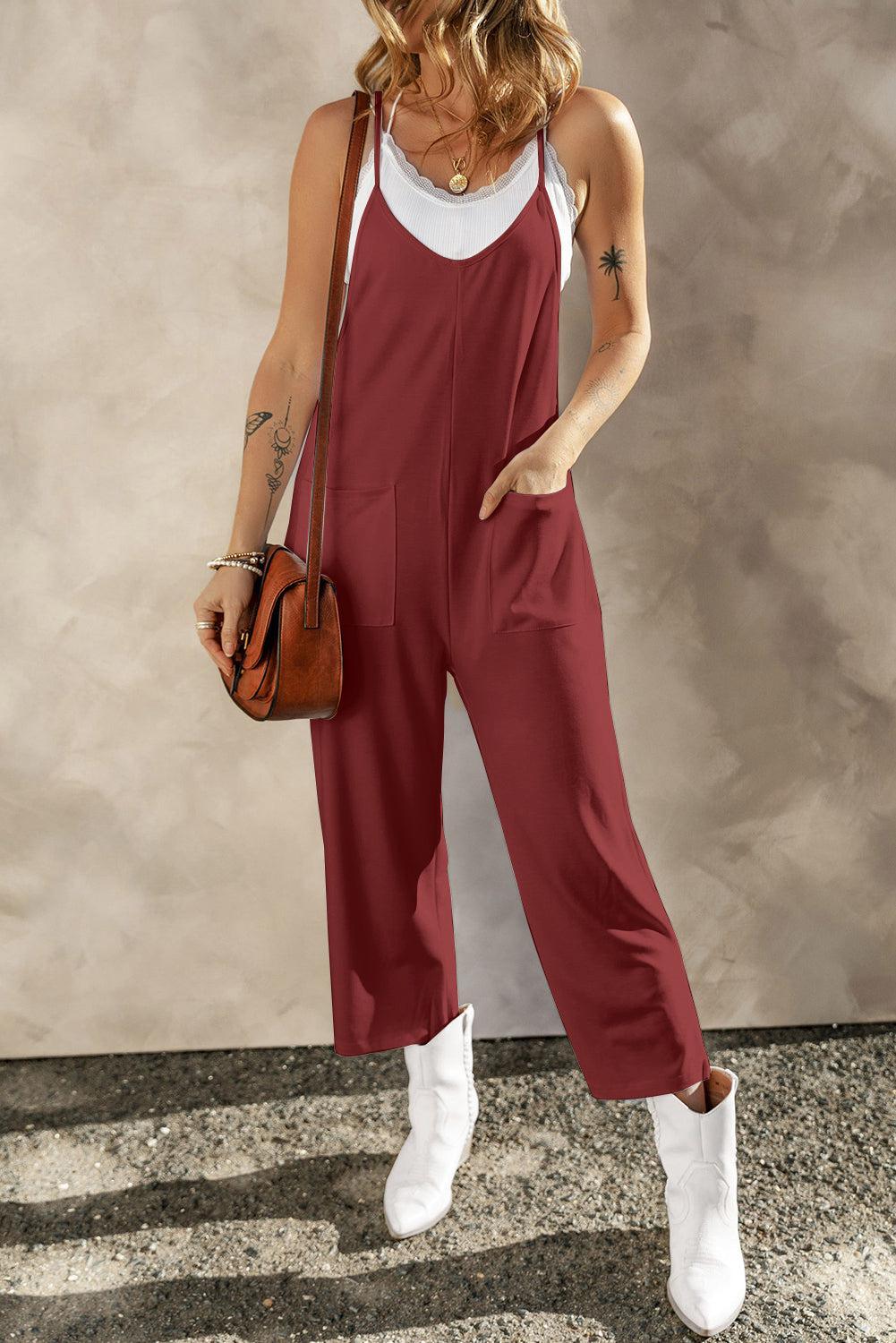 a woman in a red jumpsuit holding a brown purse