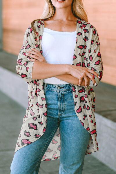 a woman wearing a leopard print cardigan and jeans