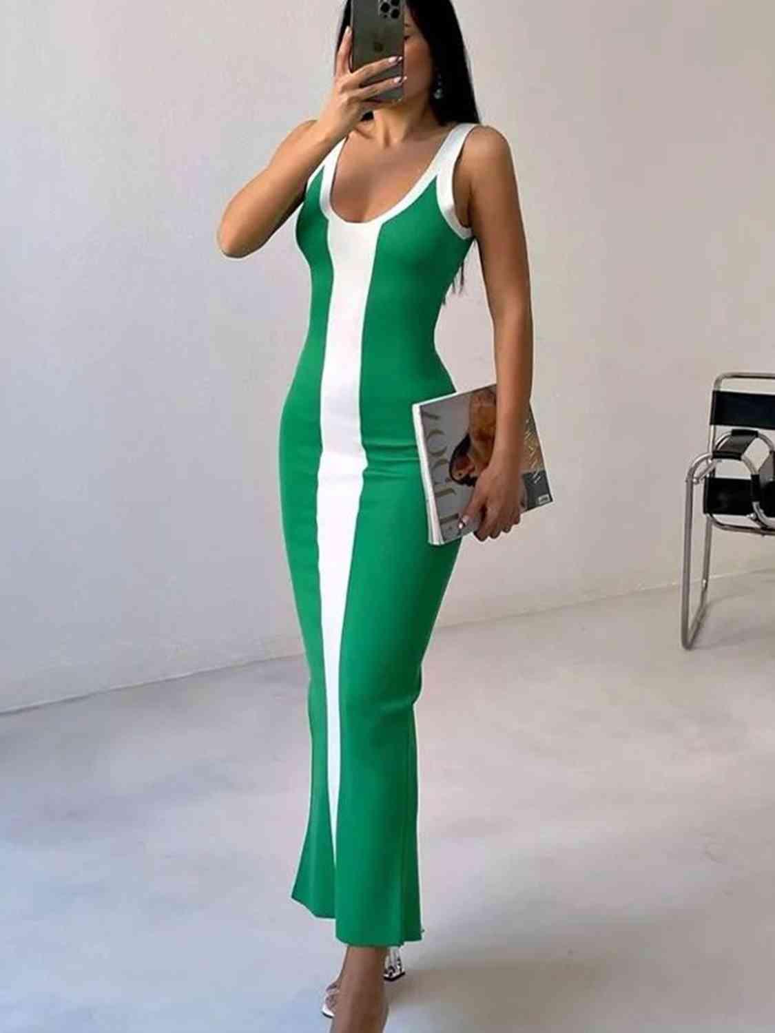 a woman taking a picture of herself in a green and white dress