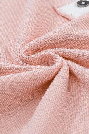 a close up of a pink polo shirt