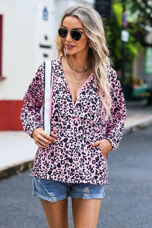 a woman wearing a pink and black leopard print shirt