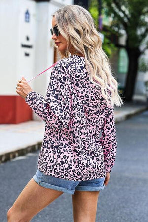a woman wearing a pink leopard print jacket and denim shorts