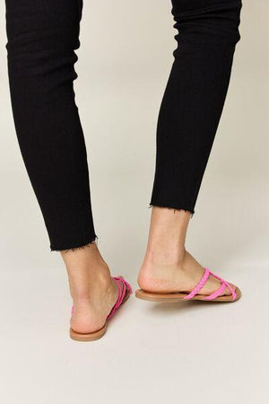 a woman in black pants and pink sandals