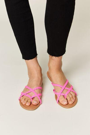 a woman wearing pink sandals and black pants
